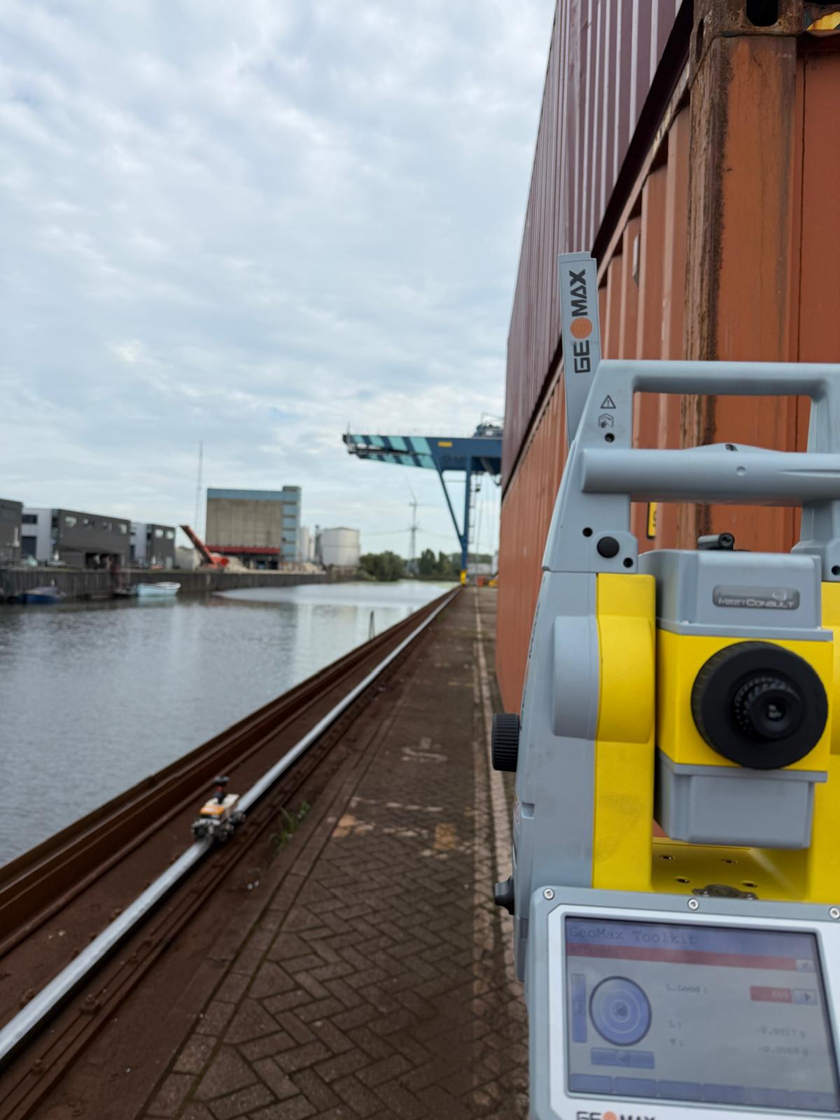 Total station en meettrolley op een kraanbaan langs de kade